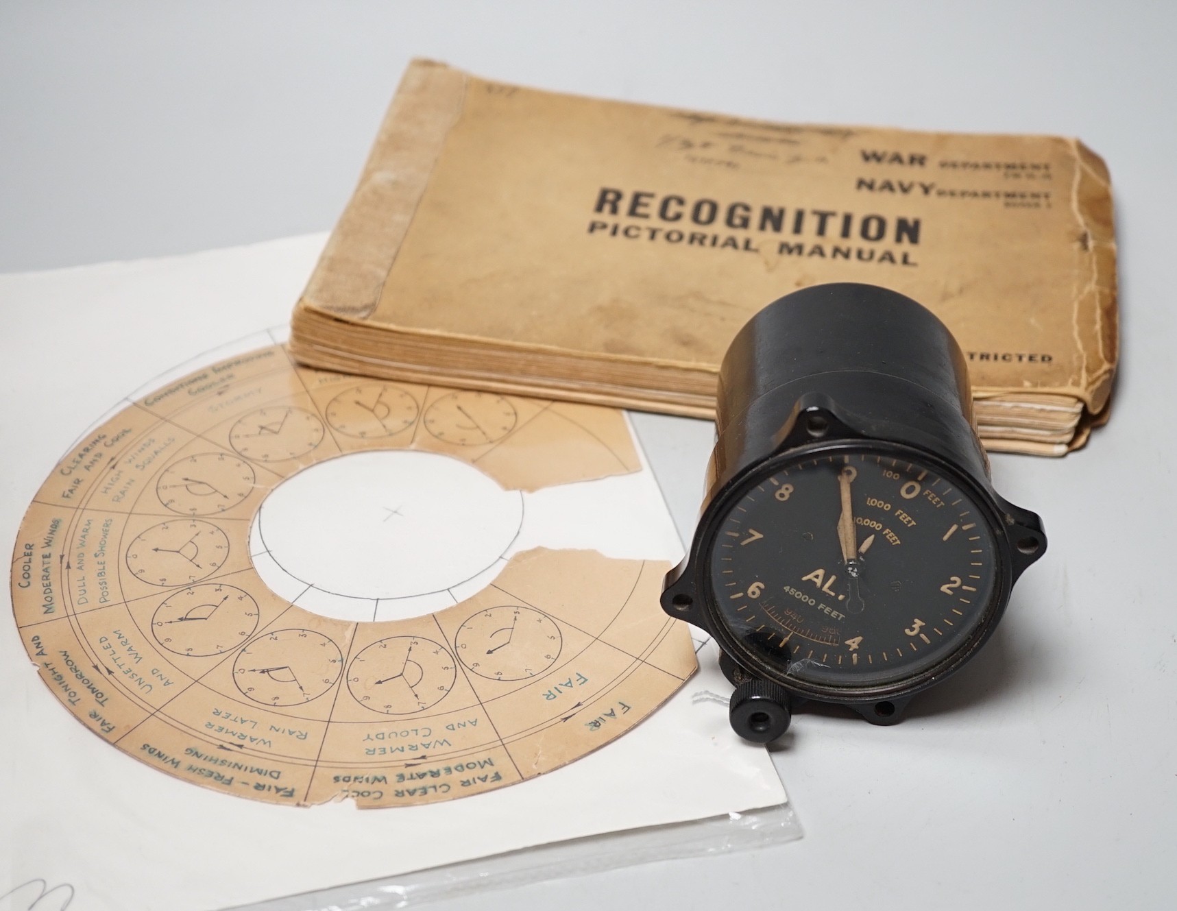 A WWII Air Ministry altimeter model XIV B and a War & Navy Department aircraft recognition pictorial manual